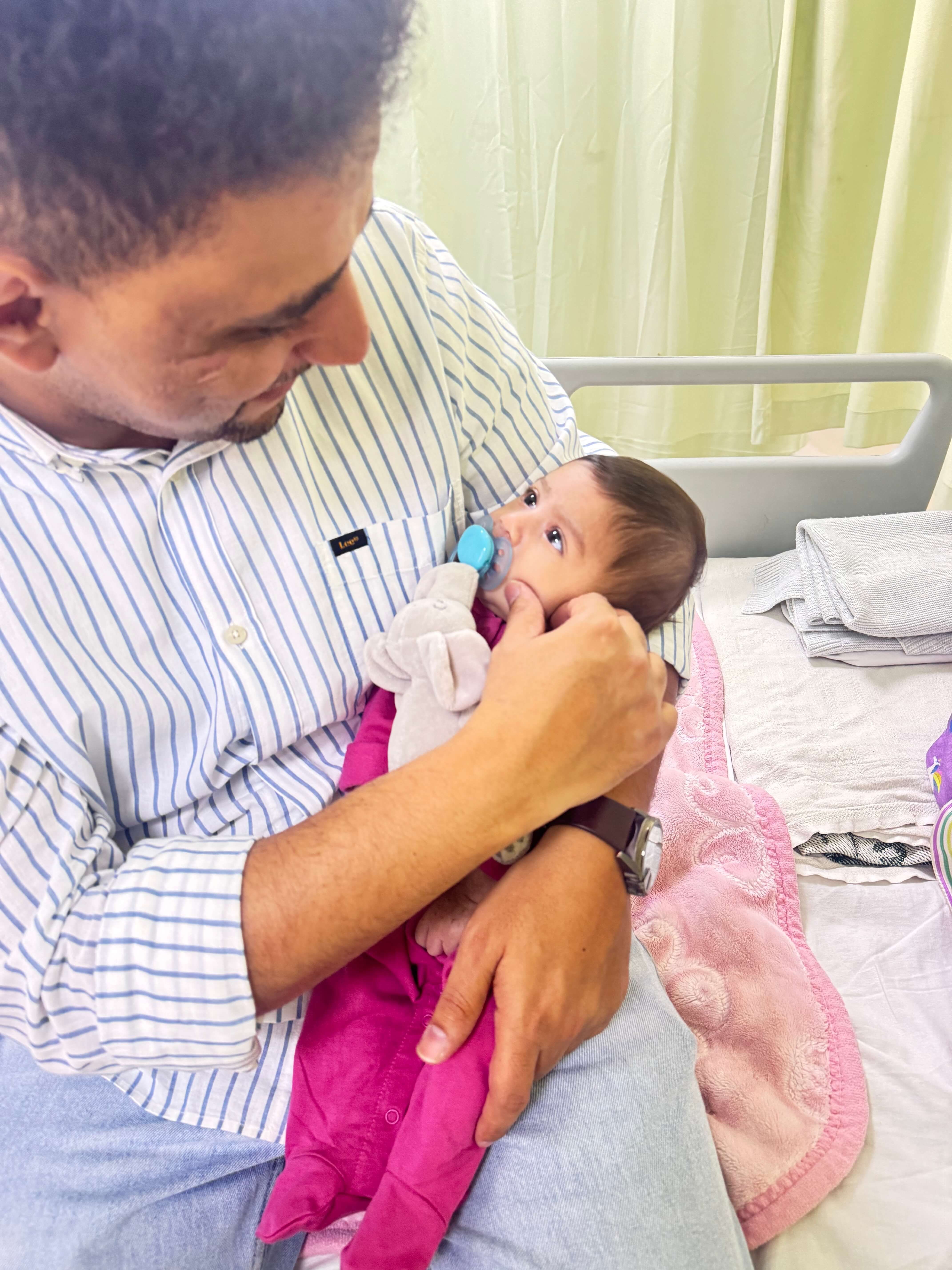 Mahmoud AlSharif holding Aisha during her hospital stay